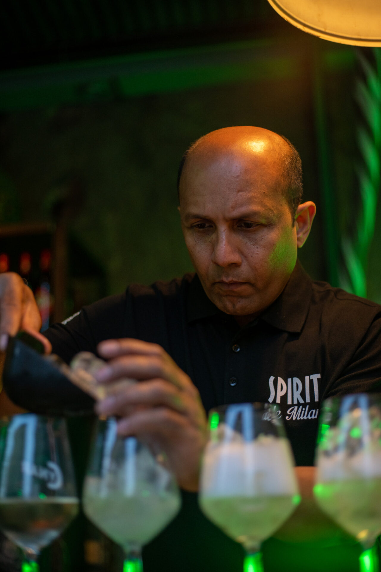 a bald man holding a glass of wine