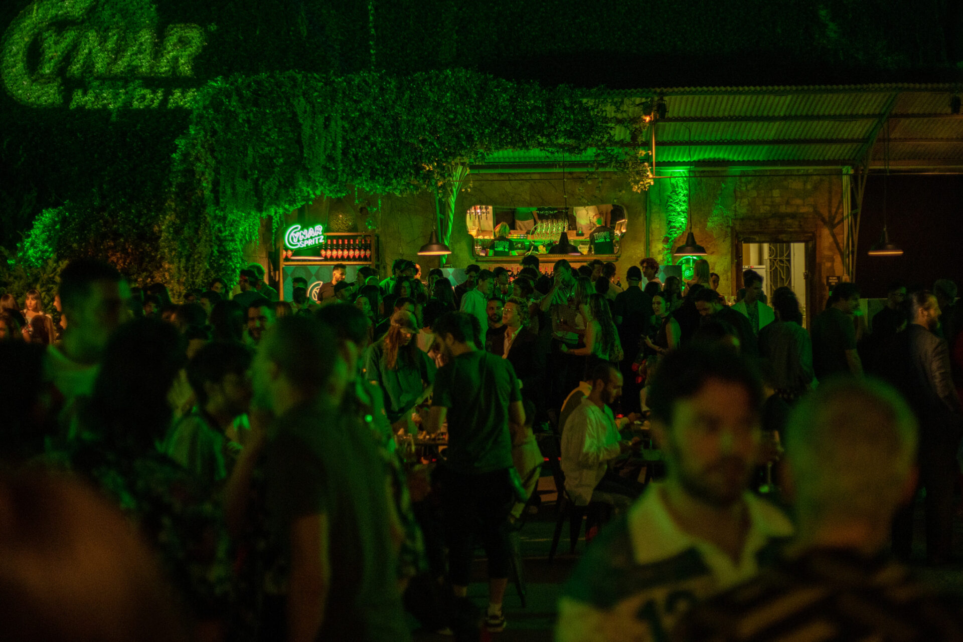 a crowd of people in a dark room with green lights