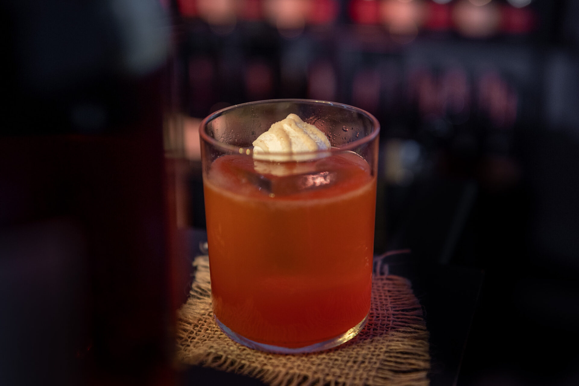 a glass of orange drink with a slice of lemon on top