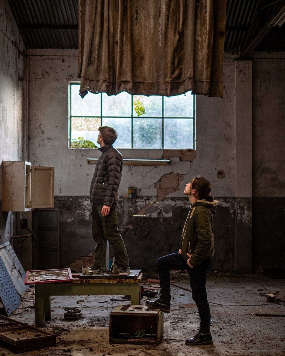 a man and a woman in a room with a table and a window