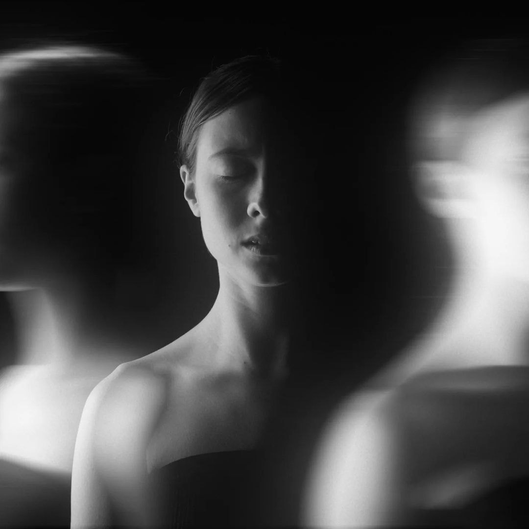 a person black and white with two ghosts