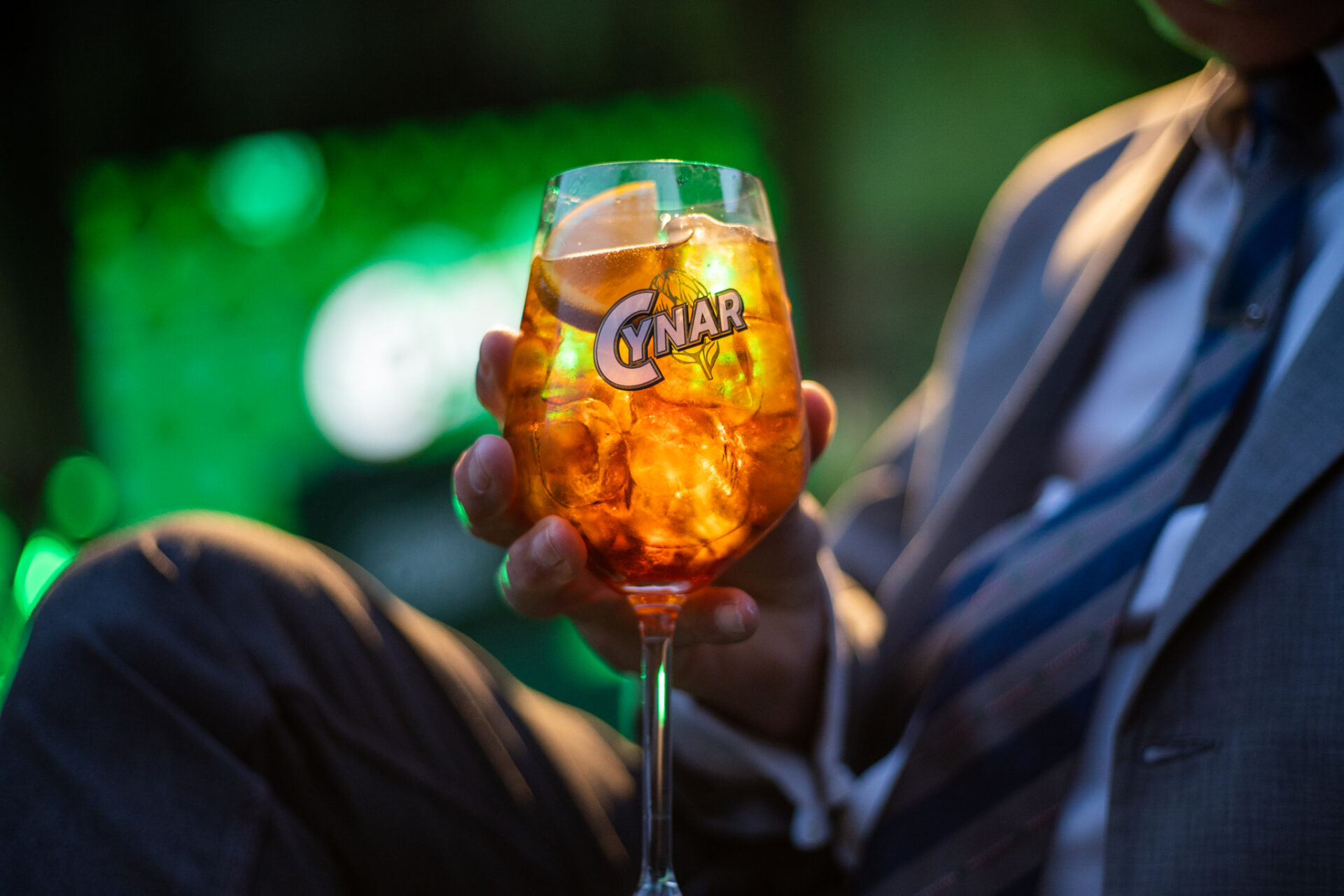 a person holding a glass of liquid
