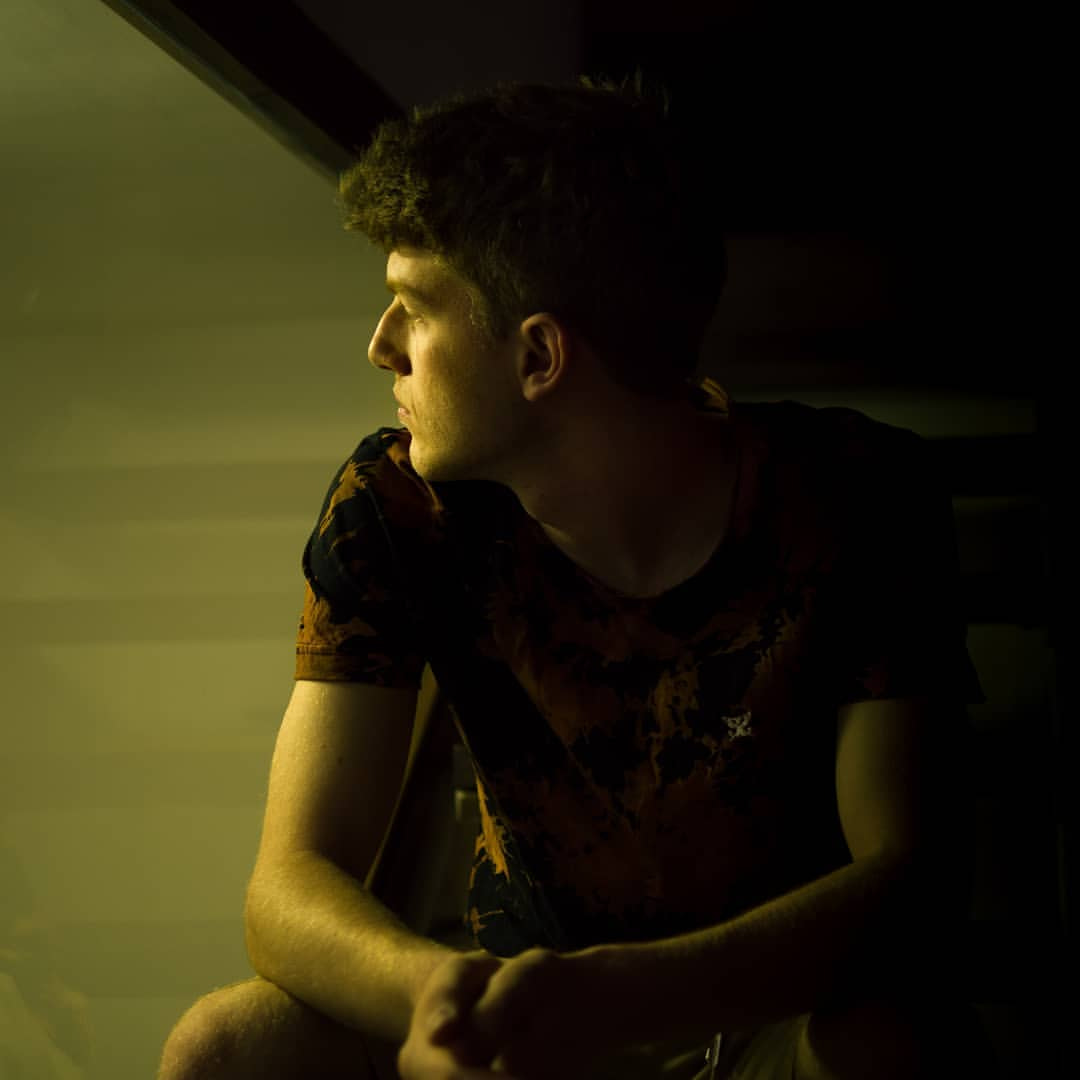 a person sitting in the shadows
