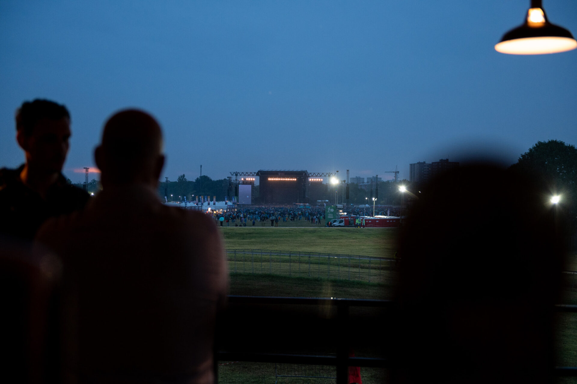 people looking out a window at a field at night
